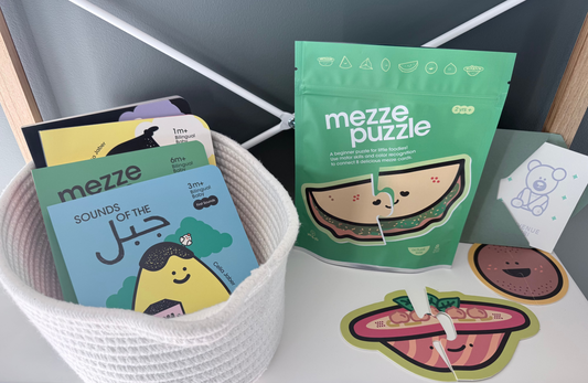 Mezze children's books and puzzle on a white surface with a gray wall background