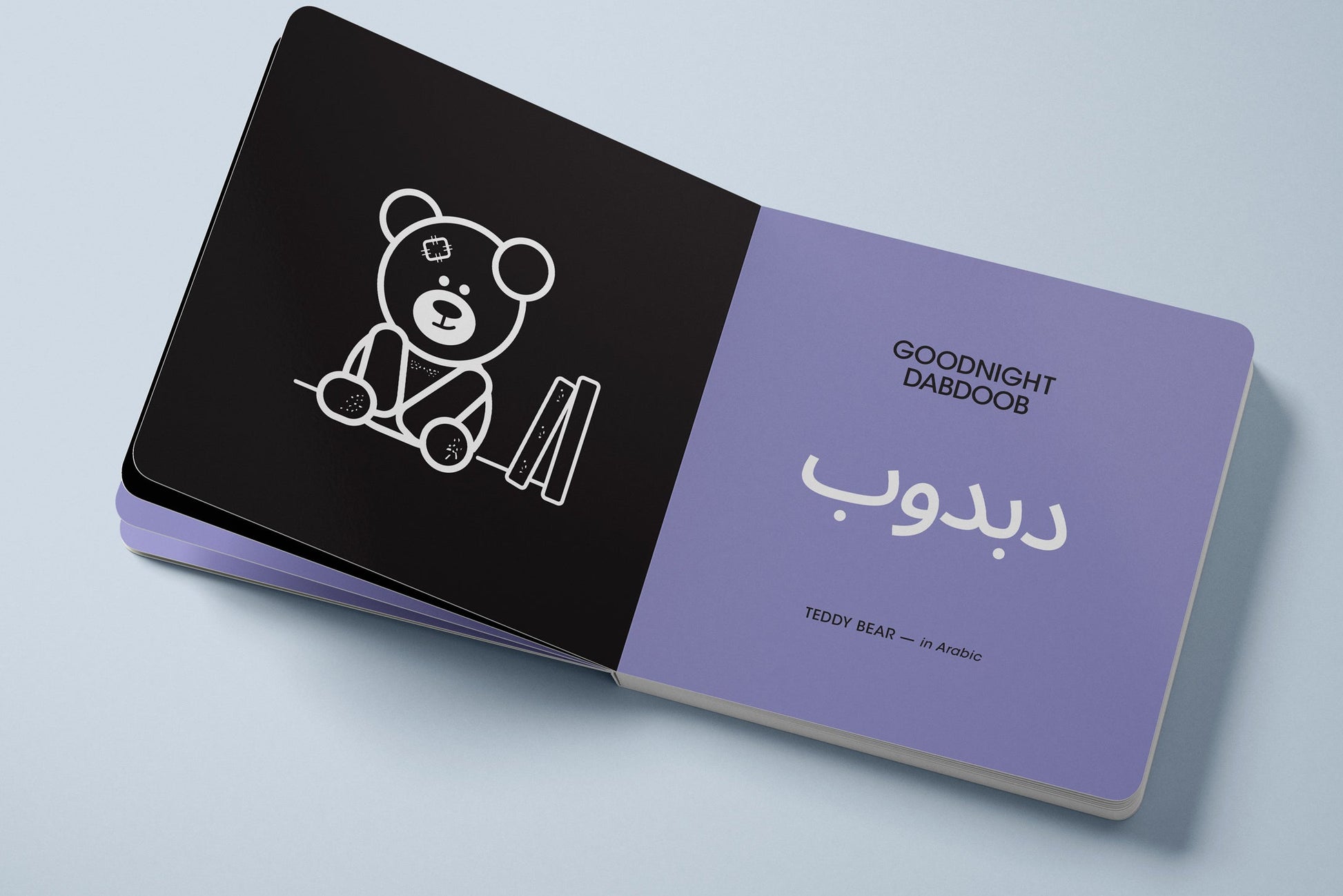 Board Book inside spread, one side black with a teddy bear illustration and the other lavender with Arabic text.